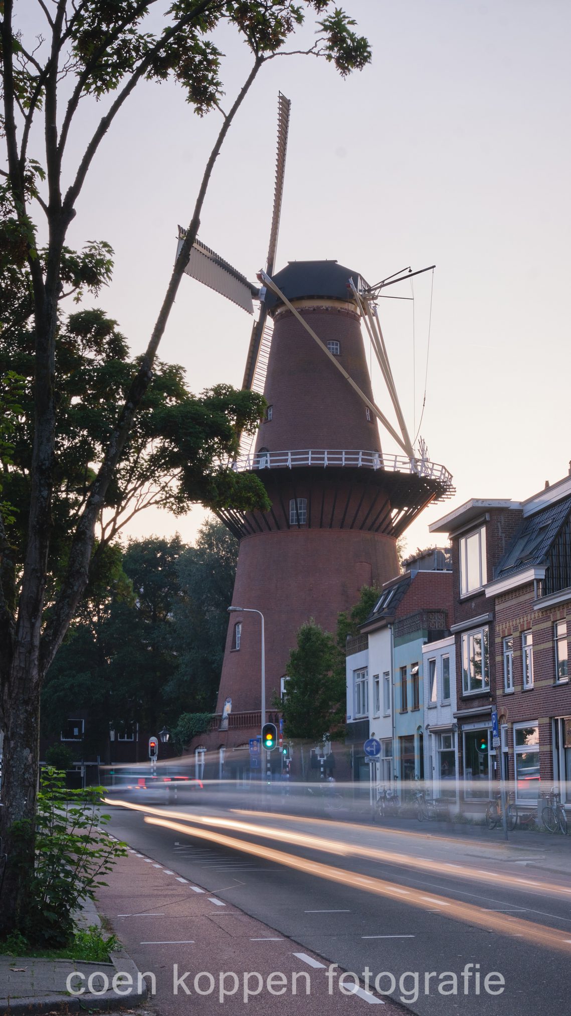 Adelaarstraat met lichtstrepen van auto's met blik op molen Rijn en Zon - Coen Koppen Fotografie