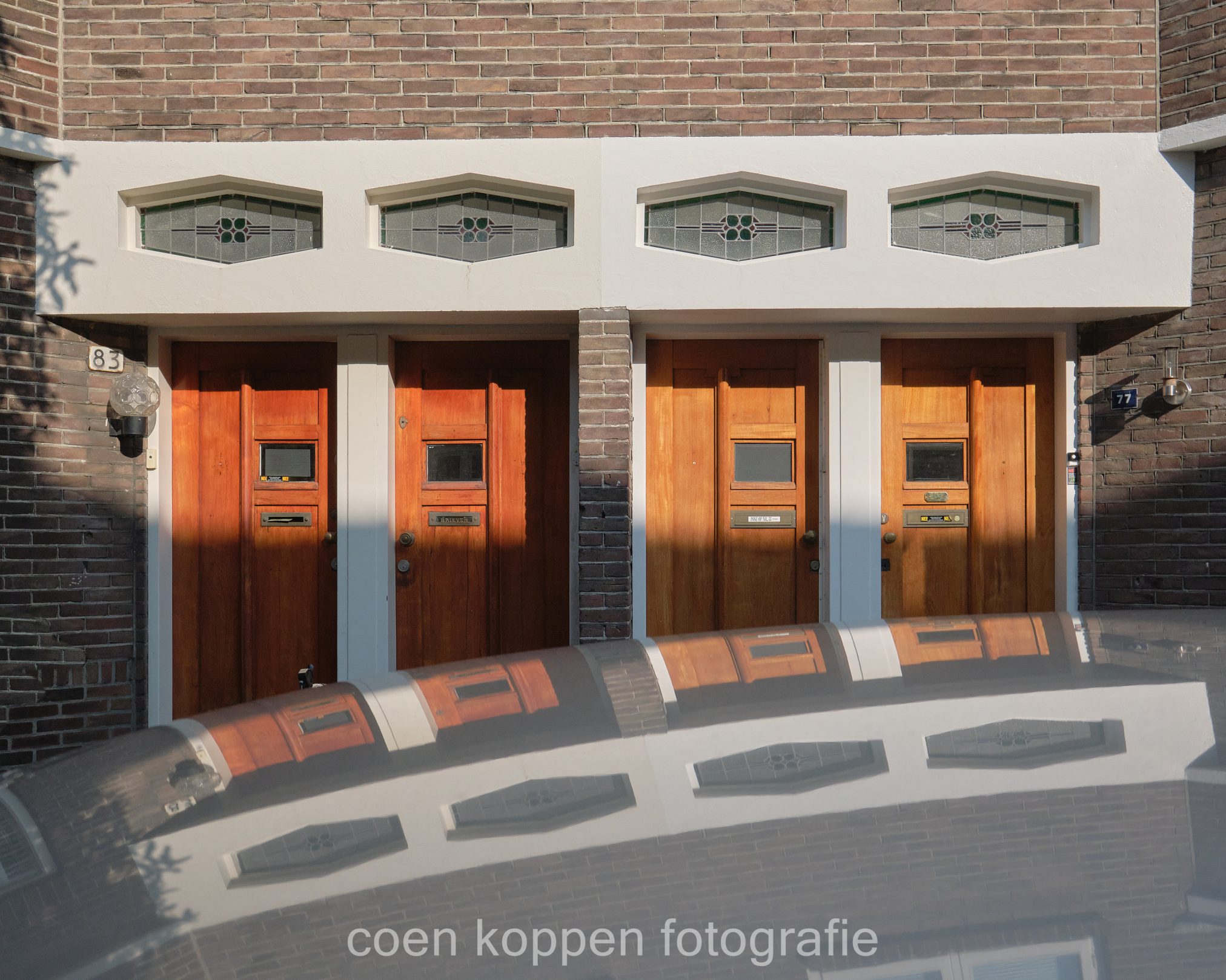 Architectonisch detail. Amsterdamse school raampjes boven de deuren van de Jan van der Doemstraat in Tuinwijk Utrecht - Coen Koppen Fotografie